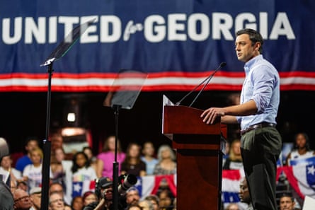 a man speaks into a microphone in front of a crowd of people