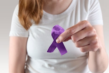 A woman holding a purple awareness ribbon for Domestic Violence and Alzheimers Awareness.