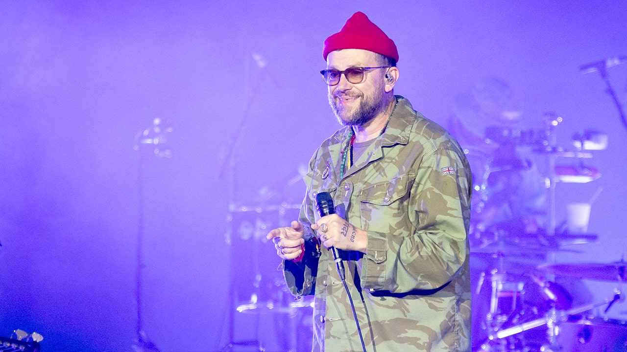 O vocalista da banda Gorillaz, Damon Albarn, segura uma bandeira palestina durante um show após a remoção de Macklemore do tour.