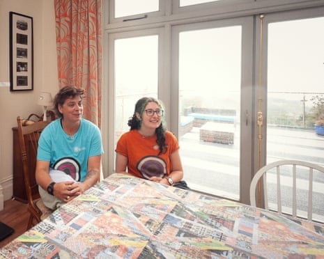 Festival director on left in a light blue T-shirt and guesthouse manager on right in an orange T-shirt, both seated at table.